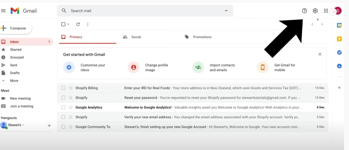 Gmail inbox with an arrow pointing toward the settings gear.